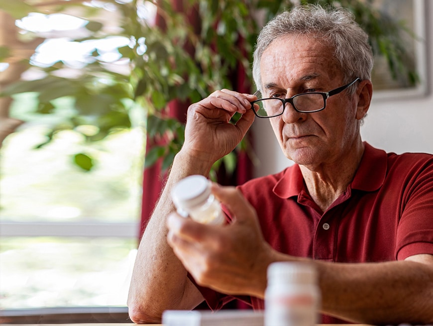 man leest de bijsluiter van zijn medicatie