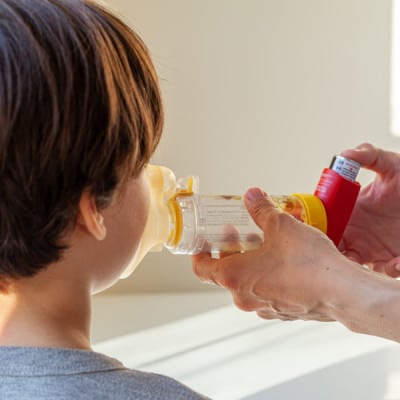 Kind met astma gebruikt inhalator