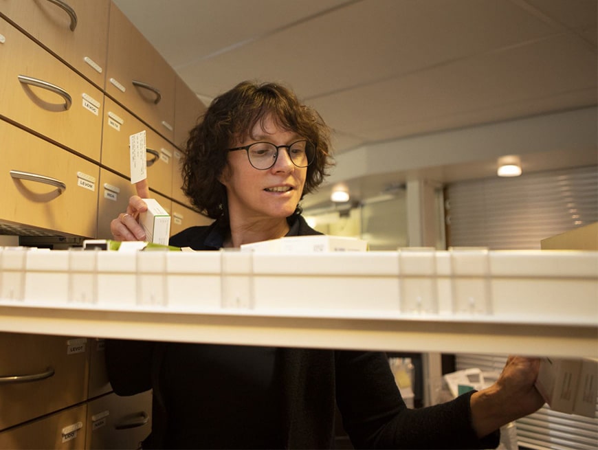 Apotheker pakt medicatie uit de medicijnkast