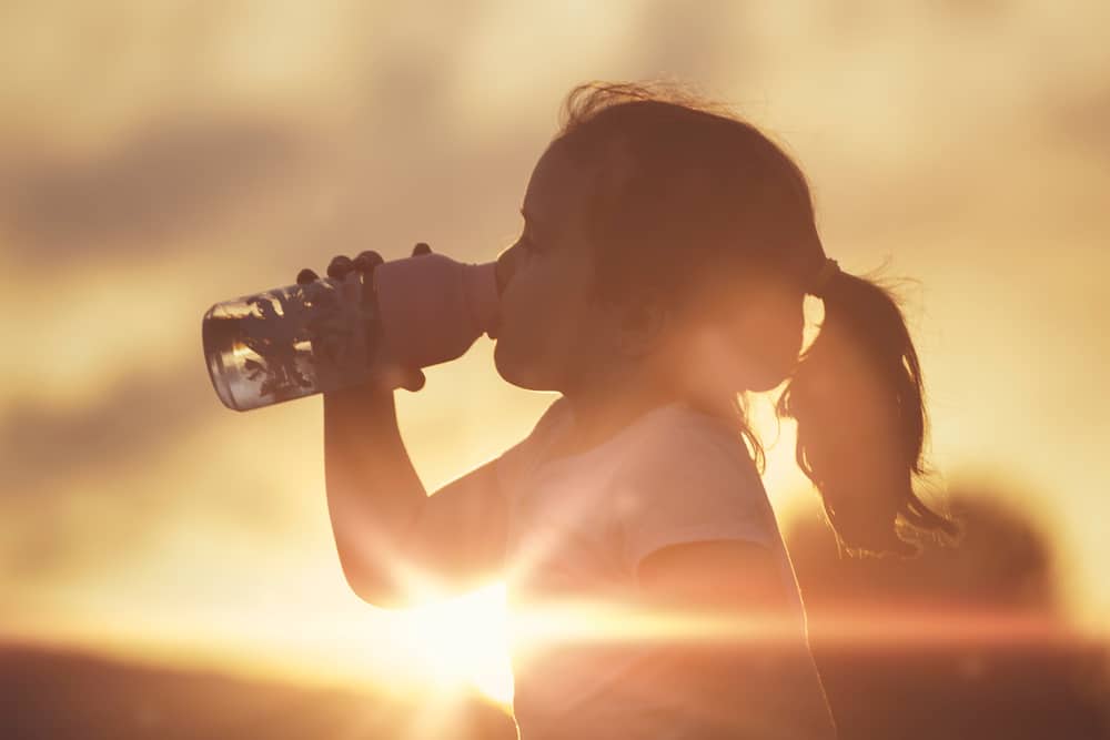 kind drinkt water tijdens een warme dag