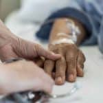 Palliatieve patiënt houdt hand vast van dierbare