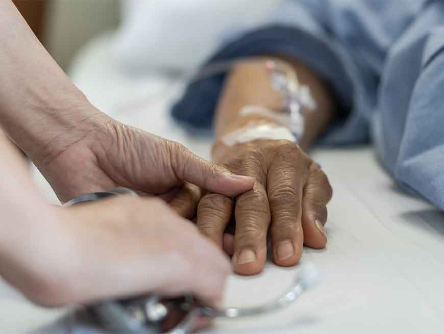 Palliatieve patiënt houdt hand vast van dierbare